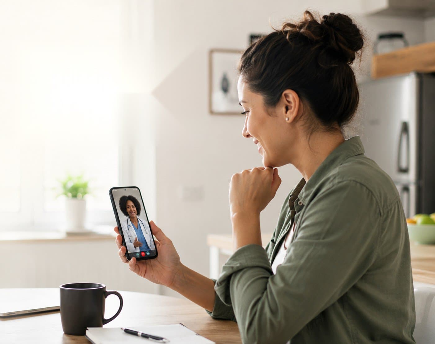 A woman on a video consult with a doctor from her kitchen