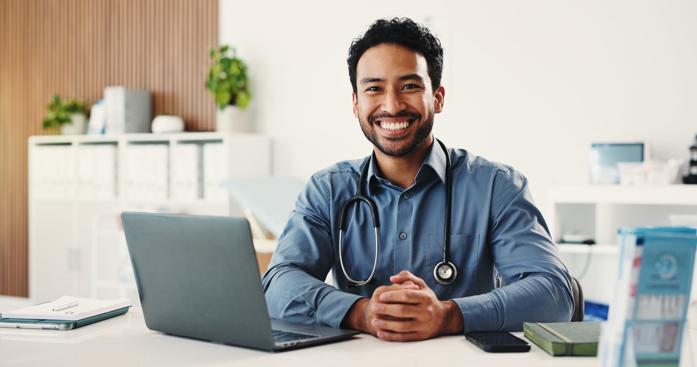 A doctor smiling at his practice desk