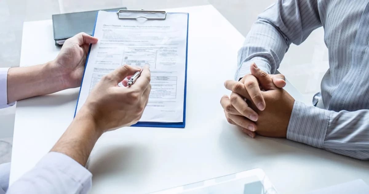 A professional completing paperwork while meeting with a client