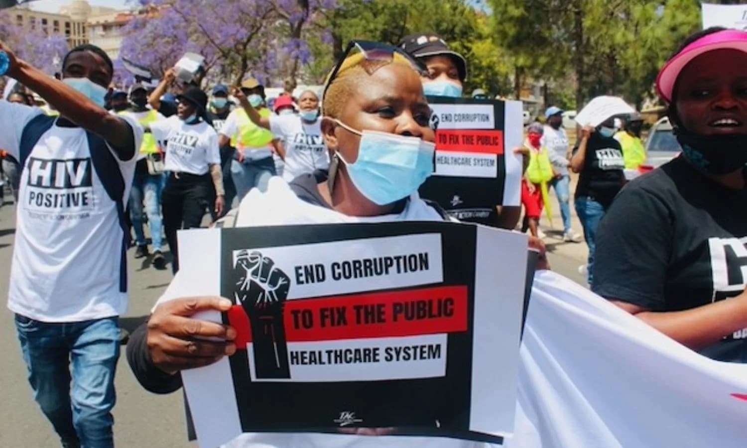 Protesters carrying signs calling for an end to corruption in the public healthcare system