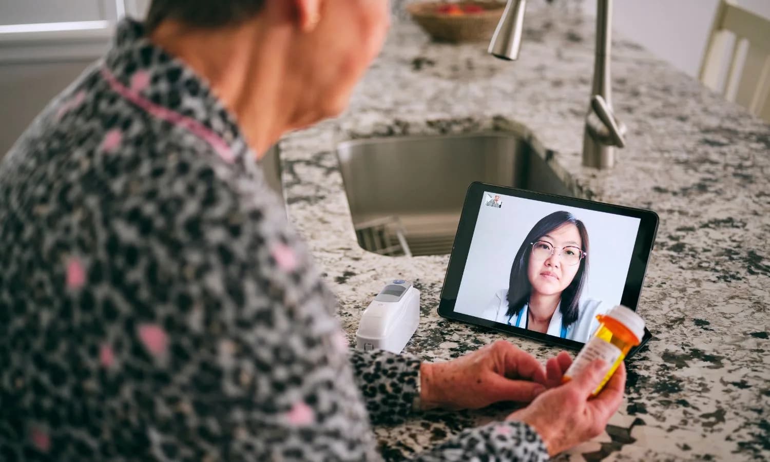 An older patient discussing prescription medication with a doctor by video call